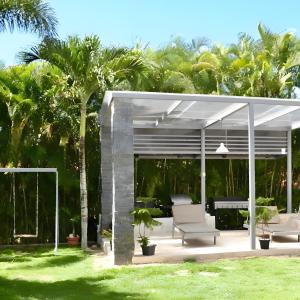 a white pergola with a bench and a piano at Majestuosa villa en Juan Dolio, Guavaberry Golf & Country Club in Juan Dolio