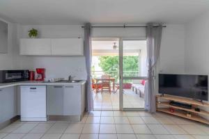 a kitchen with a television and a living room at Kaz Mitan in Les Trois-Îlets