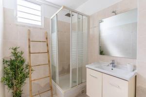 un bagno con lavandino e doccia con specchio di Kaz Mitan a Les Trois-Îlets