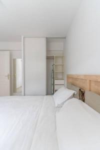 a bedroom with a large white bed and a mirror at Kaz Mitan in Les Trois-Îlets