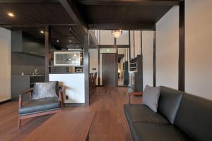 ein Wohnzimmer mit einem Sofa und einer Küche in der Unterkunft Takeya Tenmangu in Kyoto
