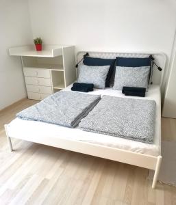 1 dormitorio con cama blanca y almohadas azules en CORSO Central Home, Keszthely en Keszthely