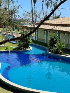 une grande piscine bleue en face d'une maison dans l'établissement O Paraíso é aqui: Pé na Areia em Arembepe, à Camaçari