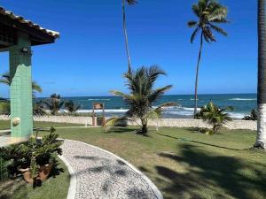 a view of the beach from a resort with palm trees at O Paraíso é aqui: Pé na Areia em Arembepe in Camaçari