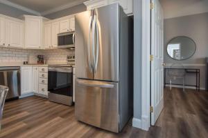 - un réfrigérateur en acier inoxydable dans une cuisine avec des placards blancs dans l'établissement come & stay awhile, à Waukee
