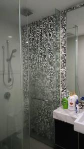 een badkamer met een douche en een glazen deur bij Cozy M Suites Android Box, Pool and City Area in Kuala Lumpur