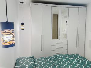 um quarto com uma cama e um armário branco em Apt nuevo 15min CC BuenavistValmundo TV50 Netflix em Barranquilla