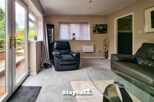 ein Wohnzimmer mit einem Sofa und einem Stuhl in der Unterkunft Quiet Annex With Lovely Garden And Parking in Bredbury