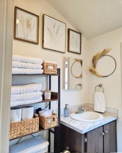 a bathroom with a sink and a mirror and towels at Buffalo Jump Guest House in Three Forks