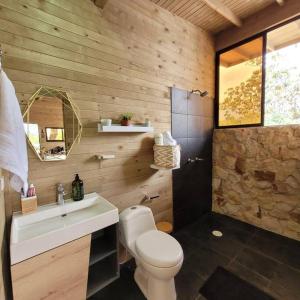 a bathroom with a white toilet and a sink at Kuyana Glamping in Cali