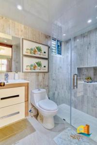 a bathroom with a toilet and a shower at PEACEFUL CONDO 3 BED 3A/C WIFI POOL in Santiago de los Caballeros