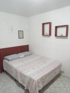 ein Bett in einem Schlafzimmer mit zwei Spiegeln an der Wand in der Unterkunft Hospedaria Mirante da maré ap6 in Imbituba