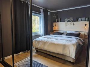 um quarto com uma cama grande e uma janela em Nyoppusset hus med utsikt. em Steinkjer