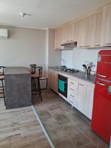 a kitchen with a red refrigerator and wooden cabinets at Departamento in Puerto Montt
