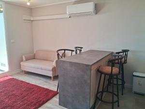 a kitchen with a bar with stools and a couch at Departamento in Puerto Montt