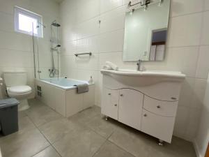 a bathroom with a sink and a toilet and a mirror at Casa Patagonia in Puerto Natales