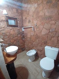 La salle de bains en pierre est pourvue de toilettes et d'un lavabo. dans l'établissement Cabañas Misioneras, à San Ignacio