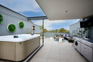a kitchen with a large sink and a patio at 2BR Penthouse Apt Rooftop Terrace, Spa & BBQ in Melbourne