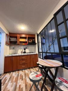 a kitchen with a table and two stools and a table at APARTASUITES BOGOTA 53 - 101a in Bogotá