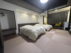佐渡市的住宿－志屋日式旅館，一间卧室配有两张床和一张桌子及椅子