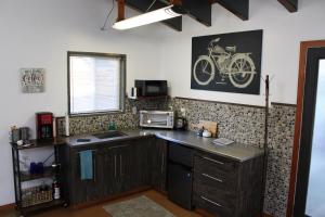 a kitchen with a counter top with a bike on the wall at Private Bright Modern Studio! Queen bed ! in Victoria