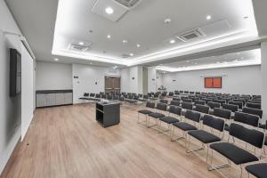 una sala conferenze vuota con sedie e un podio di City Express Junior by Marriott Leon Centro de Convenciones a León