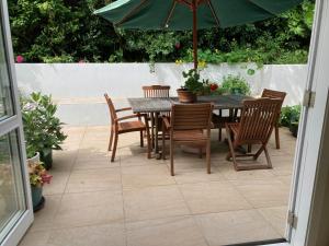 a table and chairs with an umbrella on a patio at Khandallah Harbour View BnB in Wellington
