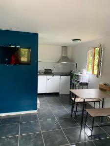 eine Küche mit einem Tisch und einer blauen Wand in der Unterkunft Chalet des capucines in La Plaine des Palmistes