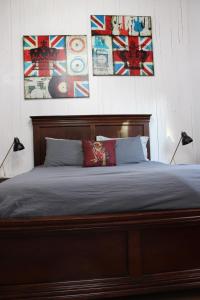 a bedroom with a bed with two paintings on the wall at Private Bright Modern Studio! Queen bed ! in Victoria