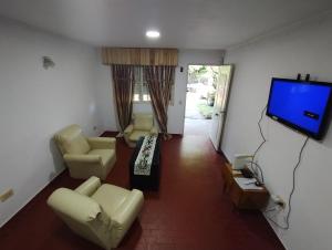 ein Wohnzimmer mit Sofas und einem Flachbild-TV in der Unterkunft Posada La Justy EZEIZA in Ezeiza