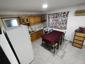 艾塞薩的住宿－Posada La Justy EZEIZA，一间带桌子和冰箱的小厨房