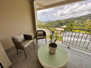 a balcony with a table and two chairs and a window at Havre de paix, en atlantique ! in Sainte-Marie