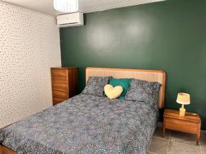 ein Schlafzimmer mit einem Bett mit einem Herzkissen drauf in der Unterkunft Havre de paix, en atlantique ! in Sainte-Marie