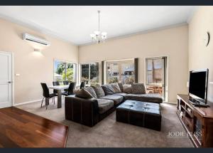 - un salon avec un canapé et une table dans l'établissement Freestanding house with ocean view, à Port Campbell