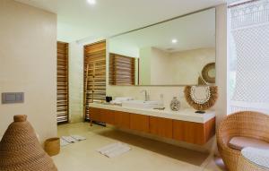 a bathroom with a sink and a large mirror at EMHILL Estate Lombok in Selong Belanak