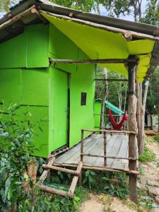 una casa verde con un'amaca di fronte di Sweet Jungle Glamping a Koh Rong Island