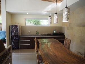 烏布的住宿－De'dalam Deluxe，厨房配有木桌、椅子和水槽