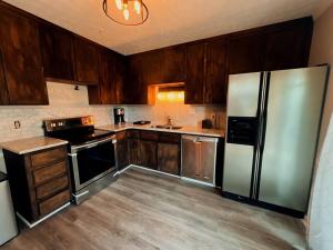 a kitchen with wooden cabinets and a stainless steel refrigerator at Recently Renovated Condo! in Athens