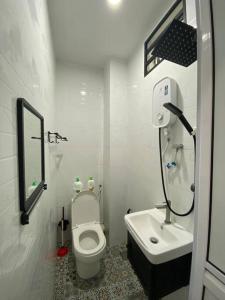 Baño blanco con aseo y lavamanos en Modern Cozy House 4Room10pax @Near Sunway Carnival en Perai