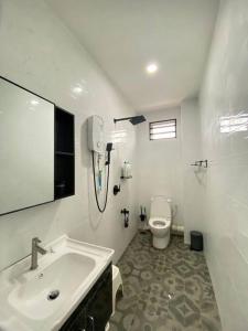 Baño blanco con lavabo y aseo en Modern Cozy House 4Room10pax @Near Sunway Carnival, en Perai