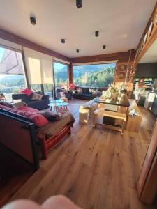 a large living room with wooden floors and large windows at Pucón, Espectacular Casa in Pucón