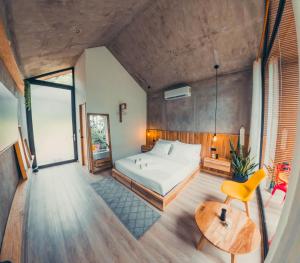 a bedroom with a large bed and a yellow chair at TAGUA LODGE in Tena