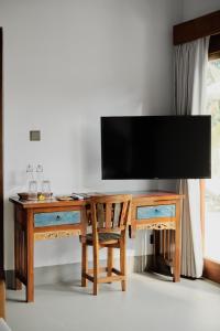 a wooden desk with a television on top of it at Suarga Loka Ubud Villa in Ubud