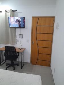 a room with a desk and a wooden door at Studio fantástico in São Paulo
