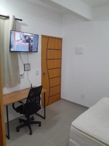 a room with a desk and a tv on the wall at Studio fantástico in São Paulo