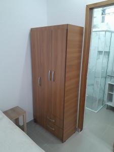 a wooden cabinet in a room with a glass door at Studio fantástico in São Paulo