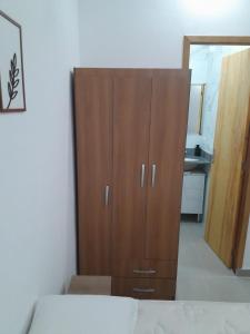 a wooden cabinet in a bedroom with a mirror at Studio fantástico in São Paulo