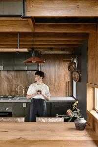 a woman standing in a kitchen at A Small, Off-Grid farm house with ocean views. in Illowa