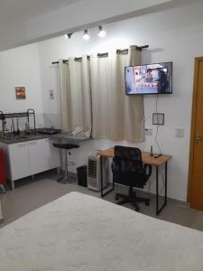 a room with a desk and a tv on a wall at Studio fantástico in São Paulo