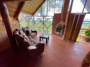 a living room with leather couches and a fireplace at Cabañas La Muralla in San Agustín